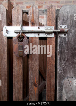 Fermoir cadenas rouillés et agrafe fixation de porte en bois à côté du bâtiment résidentiel Banque D'Images