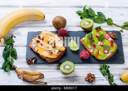 Petit-déjeuner sain avec des toasts. Sweet sandwiches au fromage à la crème et les baies fraîches et de fruits sur fond blanc. La saine alimentation et le régime alimentaire concept. À Banque D'Images