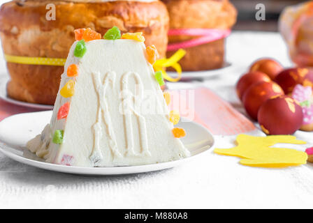 Arrière-plan de l'alimentation de Pâques. Caillé traditionnel gâteau de Pâques avec des fruits confits cookies et Pâques oeufs peints sur la table lumineuse maison de vacances Banque D'Images