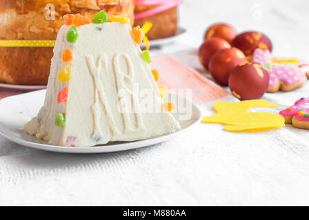 Arrière-plan de l'alimentation de Pâques. Caillé traditionnel gâteau de Pâques avec des fruits confits cookies et Pâques oeufs peints sur la table lumineuse maison de vacances Banque D'Images