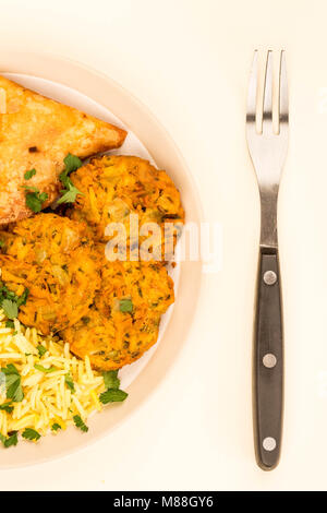 Onion Bhajis et Samossas avec riz pilaf sur un arrière-plan gris Banque D'Images