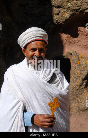 L'Éthiopie, région d'Amhara, Lalibela rock monolithe , églises construites par le roi Lalibela il y a 800 ans, l'église Saint-George, prêtre orthodoxe de Bet Giyorgis avec croix en bois / AETHIOPIEN oder Lalibela Roha, Koenig LALIBELI monolithischen Felsenkirchen liess die vor über 800 Jahren in die Basaltlava auf 2600 mètres Hoehe hauen baute und ein zweites Jérusalem, nach der Priester orthodoxer Georgskirche mit Holzkreuz, Bet Giyorgis Banque D'Images