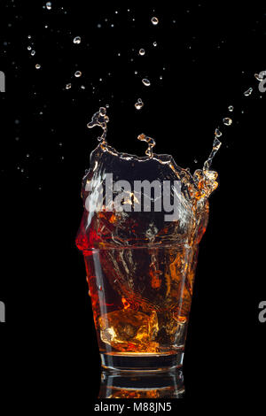 Shot de whiskey isolé avec splash sur fond noir Banque D'Images