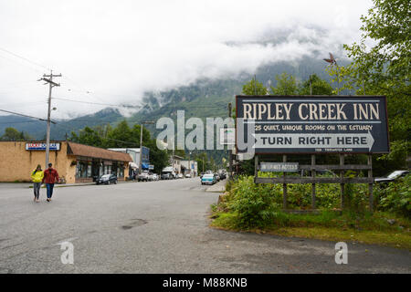 Deux résidents de la communauté de Stewart (Colombie-Britannique), traverser le secteur de la ville, sur une rue de nuages et de Brume-couverts jour, Canada Banque D'Images