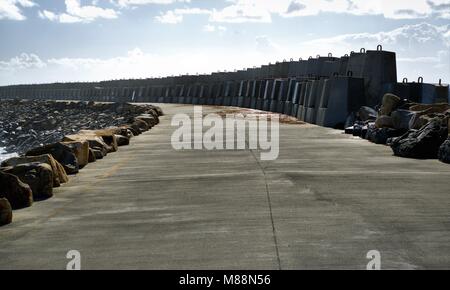 Chemin de béton d'Corambirra Point Breakwater à Coffs Harbour, New South Wales, Australie. A l'image d'un brise-lames, de grosses pierres, roches, sky Banque D'Images