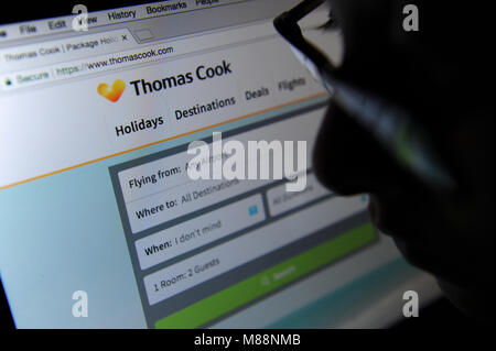 Une femme regarde le site web de Thomas Cook sur un ordinateur Banque D'Images