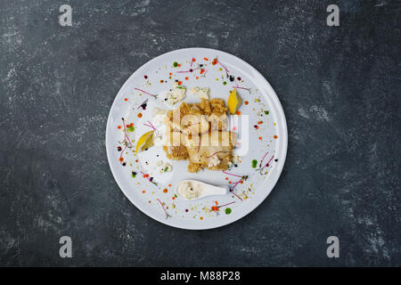 Filet de flétan sauce aux crevettes à la crème dans une assiette blanche. Banque D'Images