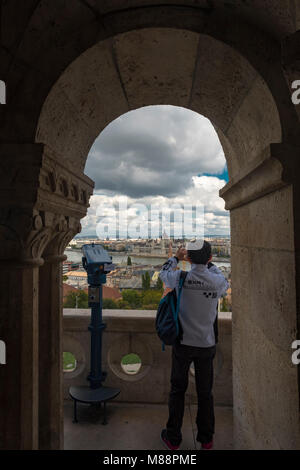 Photo de tourisme prend le Parlement de Budapest comme vu par arch dans l'église Matthias, la Hongrie. Banque D'Images