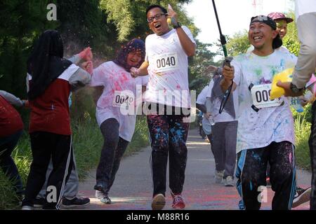 Bogor, Indonésie. Mar 16, 2018. Les participants courent à travers les nuages de poudre colorés jetés par des bénévoles au cours de la 'BIG 4K Color Run' organisé par l'Agence d'information géospatiale (BIG) Le 16 mars 2018 à Cibinong, Java ouest, Indonésie.Les participants ont couvert de poudre de craie de couleur a pris part à la course qui a été inspiré par l'Indian Holi Festival. Credit : Risa/Krisadhi Pacific Press/Alamy Live News Banque D'Images