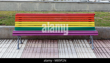 Banc peint en couleurs arc-en-ciel dans la rue Banque D'Images