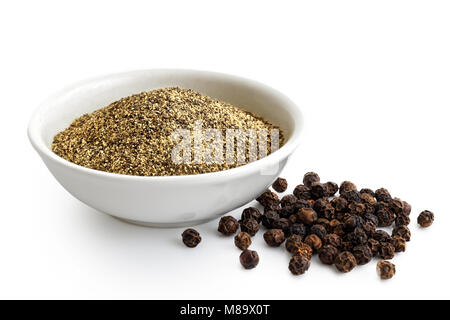 Poivre noir moulu finement dans Bol en céramique blanc isolé sur blanc. De poivre noir. Banque D'Images