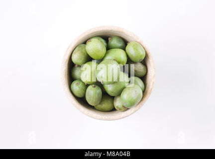 Actinidia arguta. Petits fruits kiwi dans un bol en bois. Banque D'Images