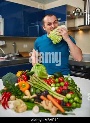 Homme avec une grande variété de légumes, prêts à être cuisinés Banque D'Images