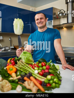 Homme avec une grande variété de légumes, prêts à être cuisinés Banque D'Images