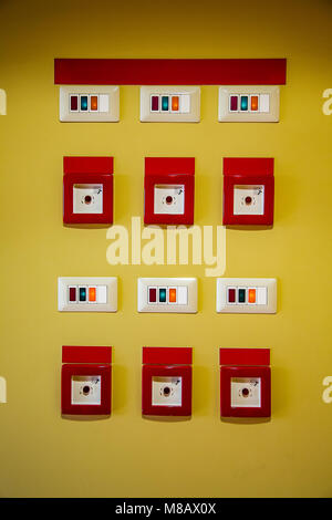 Bord de dégagement d'énergie boutons rouges sur le mur jaune Banque D'Images