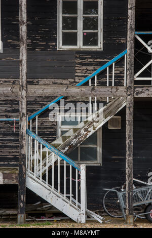 Un délabré délabrés rachitique tumbledown casse escalier de marches de bois sur le côté d'un vieux bâtiment ou côtières shabby chic cabane de pêcheur. Banque D'Images