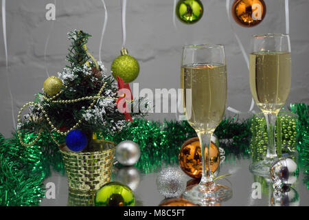 Noël encore la vie - deux verres de champagne avec des décorations de Noël rouges et arbres de Noël sur fond jaune floue Banque D'Images