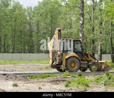 Tracteur agricole avec la benne vers le bas et le foin et paille à l'intérieur Banque D'Images