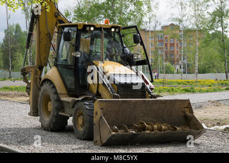 Tracteur agricole avec la benne vers le bas et le foin et paille à l'intérieur Banque D'Images