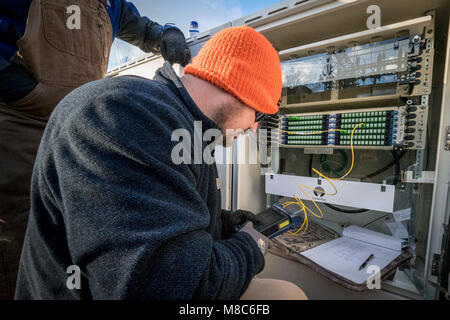 Technicien en fibre optique contrat Nathan Roten teste la connexion à fibres optiques dans l'un de ses sous-station du BARC Electric Cooperative panneaux de brassage. Le CRSB ouvre la voie dans la région de Lexington en Virginie, l'installation de câbles à fibres optiques le réseau électrique existant, ce qui permettra de porter à haute vitesse à large bande fiable pour le secteur pour la première fois. Les zones rurales où les entreprises et les consommateurs résidentiels utiliser le service à large bande sont plus susceptibles de profiter de l'augmentation des revenus, le taux de chômage plus faible et une plus forte croissance que celles qui n'ont pas le haut débit. Parce qu'à large bande offre la connectivité aux zones rurales, de l'éducation Banque D'Images