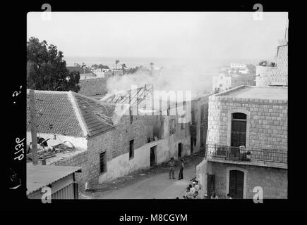 L’image capture les séquelles de Haïfa à la suite d’actes terroristes et d’actions gouvernementales. Il présente l'incendie H.M.S. dans le quartier juif, reflétant le conflit et l'implication militaire à l'époque. Banque D'Images