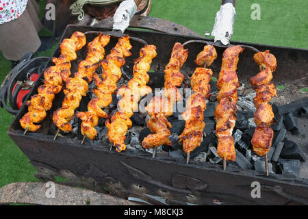 Une rôtissoire avec charbons pour la cuisson de viande marinés sur les brochettes en acier. Extérieure printemps foire traditionnelle shot Banque D'Images