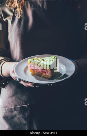 Close up view of woman holding morceau de gâteau fait maison sur la plaque dans les mains Banque D'Images
