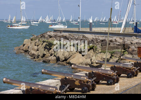 La finition des yachts de course le Tour de l'île passer le canon en laiton en face du Royal Yacht Squadron, Cowes, île de Wight, Royaume-Uni Banque D'Images