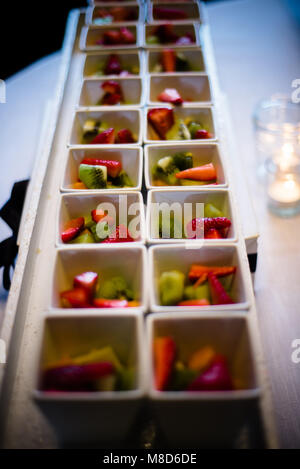 Morceaux de fruits en carré blanc tasses sur le plateau Banque D'Images