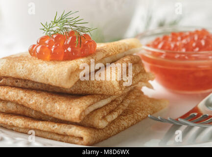 Crêpes russes traditionnelles (blinis ) avec caviar de saumon sur une plaque blanche. Selective focus Banque D'Images