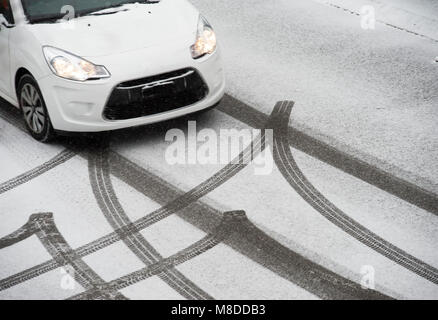 Traces d'une voiture dans la neige fraîche sur une route Banque D'Images