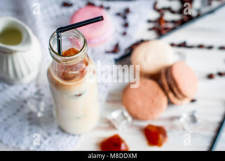 Glace café en verre, macarons,, morceaux de chocolat et les grains de café sur une table gris , vue d'en haut, copy space Banque D'Images