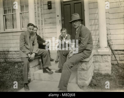 Meubles anciens c1920 photo, père et trois garçons s'asseoir sur les marches de l'assemblée. Lieu inconnu, USA. SOURCE : photographie originale. Banque D'Images