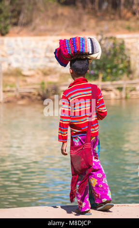 Personne avec longis repliés à vendre équilibré sur la tête à Inle Lake, près du village d'Indein, Shan State, Myanmar (Birmanie), Asie en février Banque D'Images