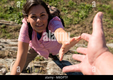 Female Rock Climber vers de coup de main au Tessin, Suisse Banque D'Images