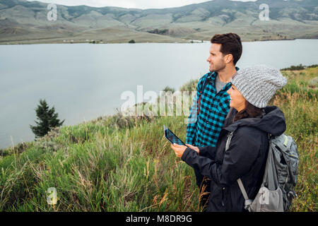 Couple debout à côté du réservoir Dillon, using digital tablet, Silverthorne, Colorado, USA Banque D'Images
