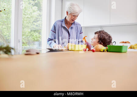 Grand-mère et petit-fils de préparer des aliments dans la cuisine Banque D'Images