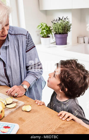 Grand-mère et petit-fils de préparer des aliments dans la cuisine, petit-fils avec l'expression en question Banque D'Images
