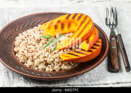 Le quinoa avec une citrouille dans la plaque d'argile. Salade chaude ou froide. Régime alimentaire. Selective focus Banque D'Images