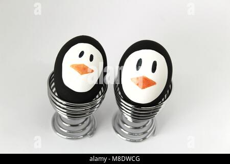 Les oeufs de Pâques pingouin fait à la main sur metal egg cup white background Banque D'Images