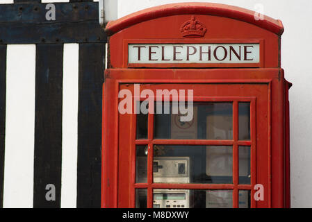 Téléphone rouge vif à cocher à côté de l'immeuble ancien à l'interdiction de fumer Banque D'Images