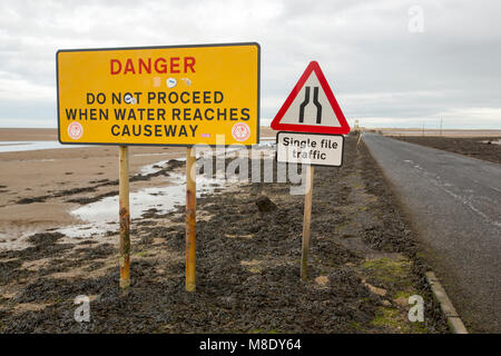 Des signes de réchauffement sur l'inondation des marées sur la chaussée à l'Île Sainte, Northumberland, Angleterre. Banque D'Images