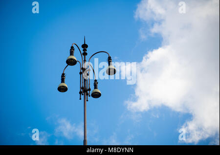 Style européen rétro éclairage urbain réverbère élevé contre le ciel bleu et grand nuage blanc Banque D'Images