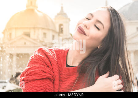 Belle jeune femme latina portrait, les yeux fermés de détente à Rome, église dome en arrière-plan Banque D'Images