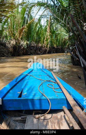 Bateau à rames de descendre une rivière dans la jungle à l'Meekong Delta, Vietnam Banque D'Images