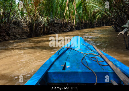 Bateau à rames de descendre une rivière dans la jungle à l'Meekong Delta, Vietnam Banque D'Images