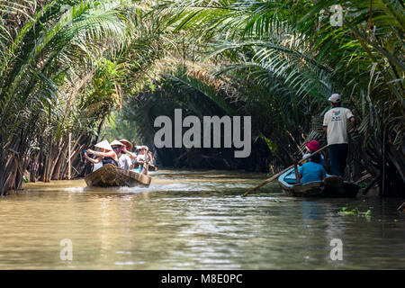 Les touristes sont pris en bas une jungle river en barques sur le Meekong Delta, Vietnam Banque D'Images