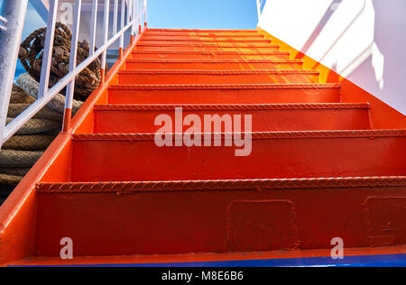 Escalier métallique orange vif à l'intérieur d'un ferry pour passagers avec un pont bleu Banque D'Images