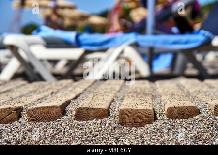 Chemin en bois sur la plage de galets pour une marche confortable jusqu'à l'eau de très près Banque D'Images