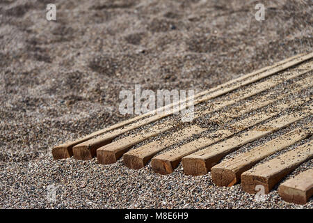 Chemin en bois sur la plage de galets pour une marche confortable jusqu'à l'eau de très près Banque D'Images